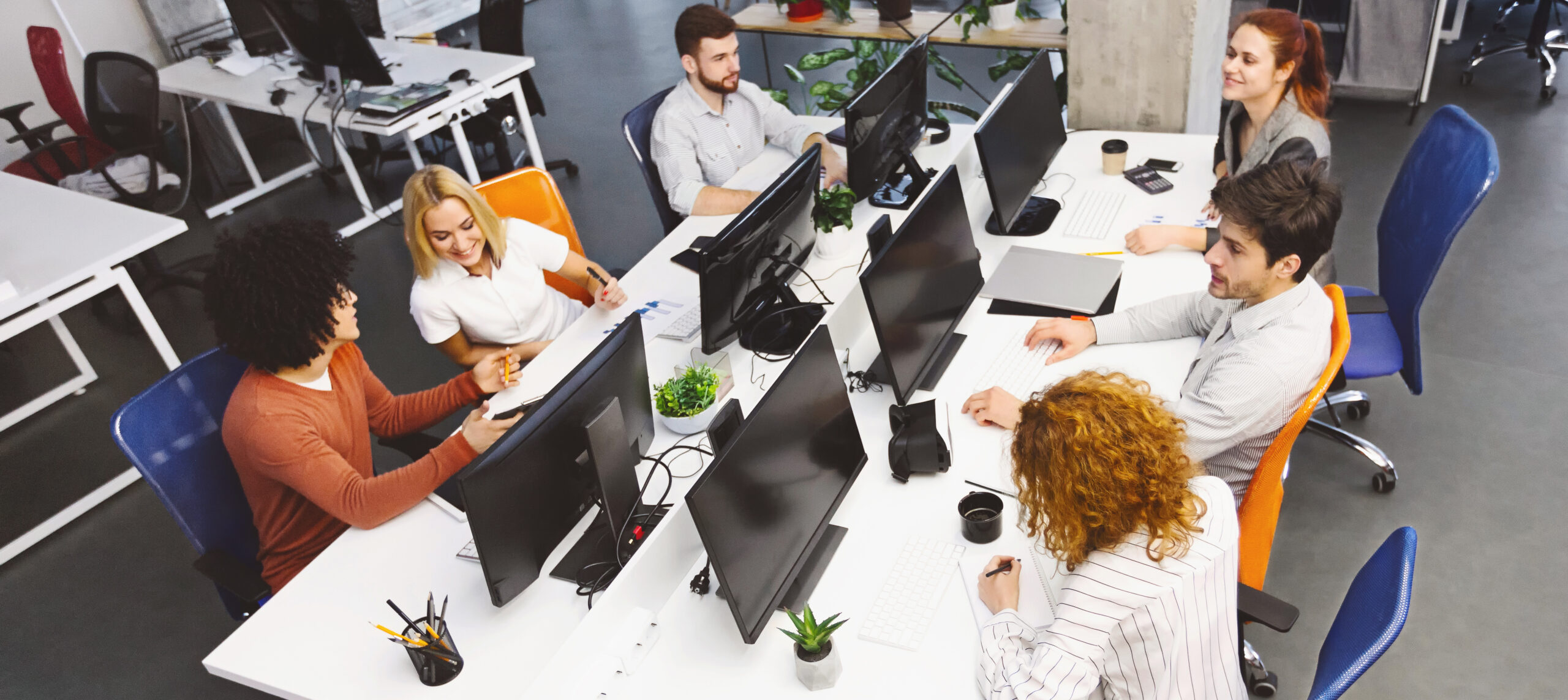 Group of young diverse people discussing project at workplace